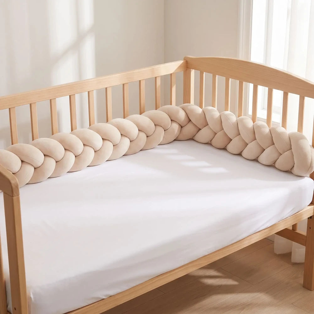 Tresse de lit beige rosé à 3 brins le long d'un lit à barreaux vide