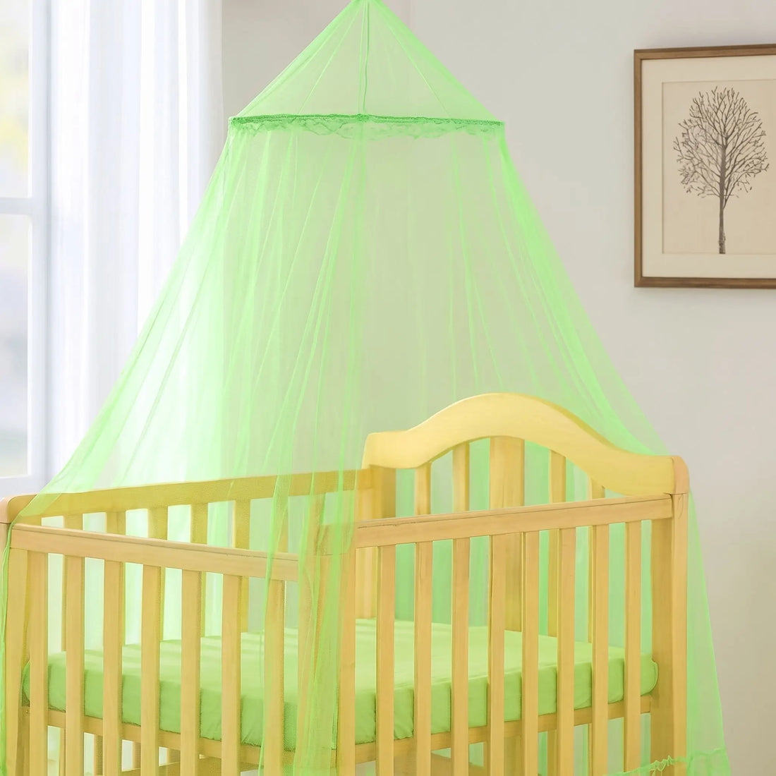 Ciel de lit moustiquaire bébé vert anis suspendu au-dessus d'un lit à barreaux vide