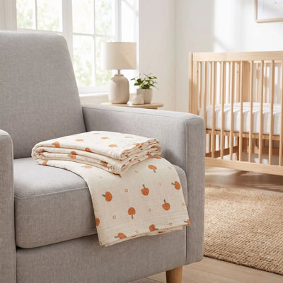 Couverture bébé en coton pliée sur un fauteuil dans une chambre de bébé