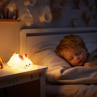 Enfant dormant paisiblement grâce à une veilleuse lapin douce.