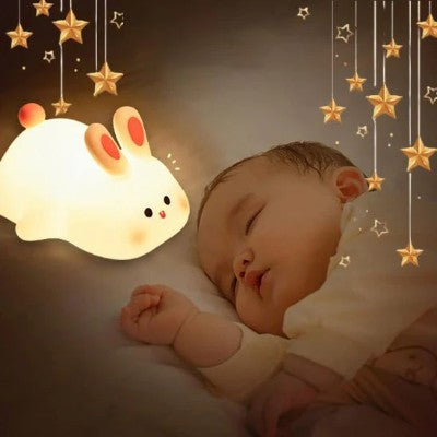 Bébé endormi près d’une veilleuse lapin apaisante.