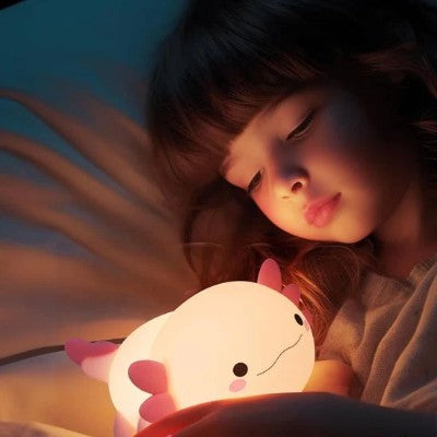 Enfant apaisé regardant une veilleuse rechargeable axolotl.