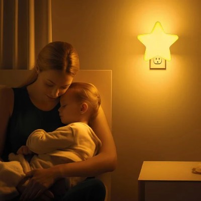 maman berçant bébé dans chambre illuminée par veilleuse murale

