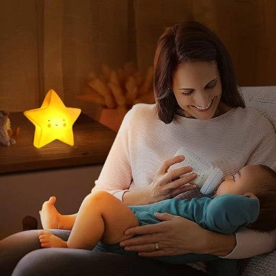 Parent apaisant bébé avec une veilleuse bébé lumineuse.
