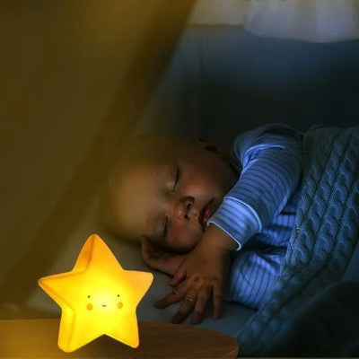 Enfant dormant paisiblement grâce à une veilleuse bébé étoile.
