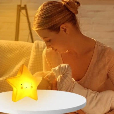 Bébé nourri tendrement près d’une veilleuse bébé rassurante.
