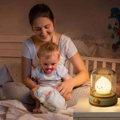 Veilleuse bébé sous cloche apaisant un moment de change.