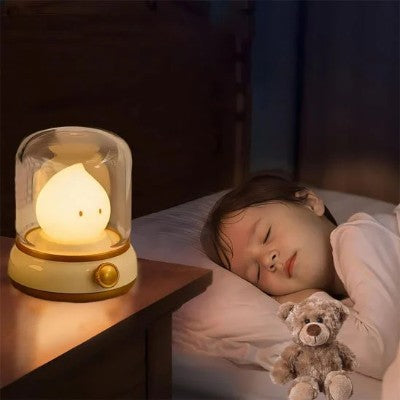 Veilleuse bébé sous cloche illuminant la chambre en douceur.