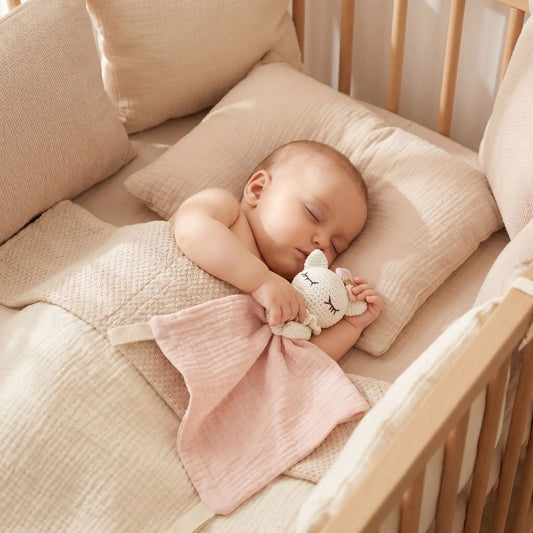 Doudou mouton rose bébé endormi serrant son compagnon de nuit