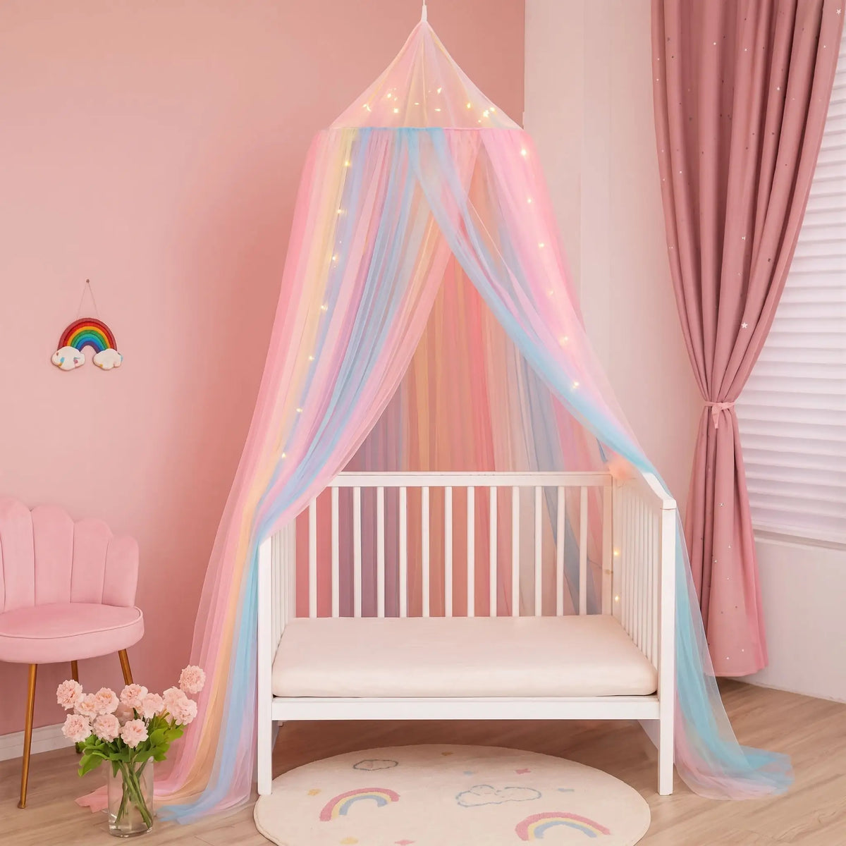 Ciel de lit bébé féerique rose et bleu dans une chambre rose, lit vide