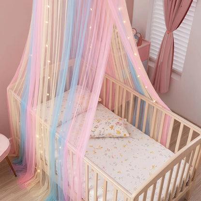 Ciel de lit bébé féerique, détail du voilage pastel autour d'un lit vide