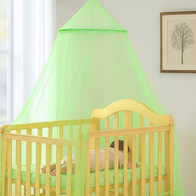 Ciel de lit bébé vert anis sur lit en bois naturel