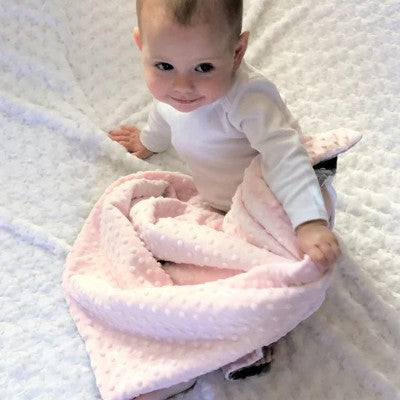 couverture bébé rose douce enveloppant bébé assis