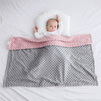 couverture bebe polaire rose et grise sur lit enfant