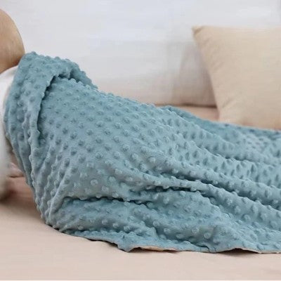 couverture bebe polaire bleue texture douce sur lit adulte