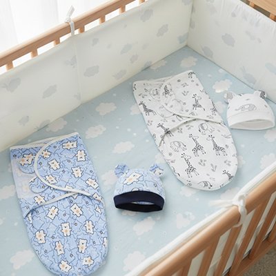 couverture emmaillotage bleue et blanche presentee dans berceau