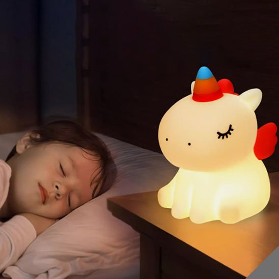 Enfant dormant paisiblement grâce à une veilleuse rechargeable licorne.