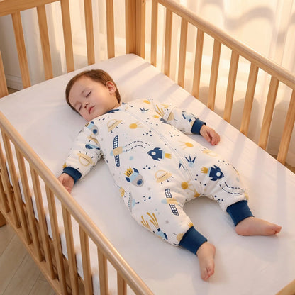 Tout-petit endormi sur le dos en gigoteuse avec jambes, dans un lit à barreaux dégagé