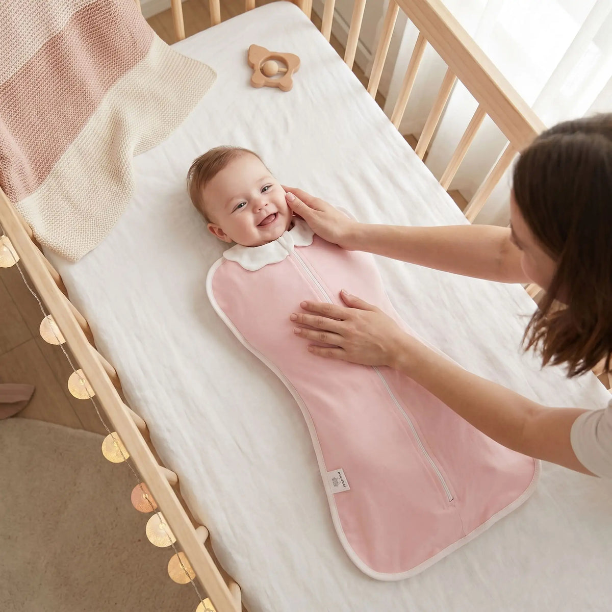 gigoteuse emmaillotage bébé rose poudré bambine souriante maman caresse