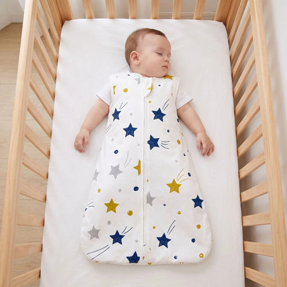Bébé endormi sur le dos en gigoteuse à étoiles, lit dégagé