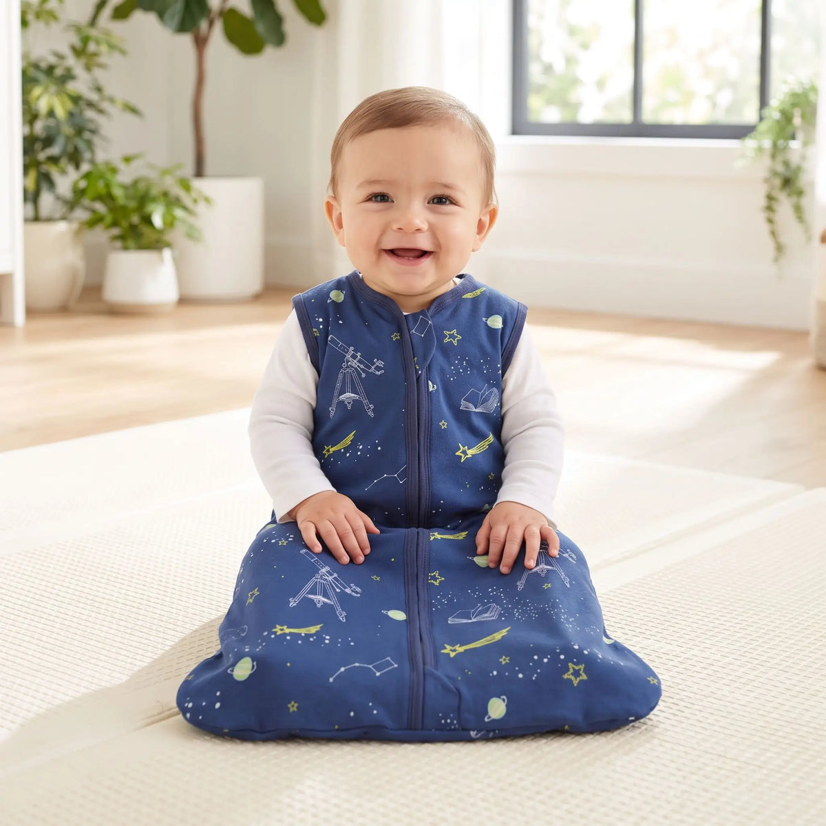 Bébé éveillé assis en gigoteuse bleu marine à motifs espace