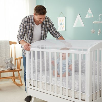Lit moustiquaire bébé papa pose filet bébé souriant