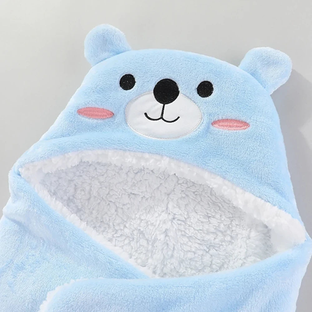 Détail de la capuche ours bleu : visage brodé et intérieur en polaire bouclée