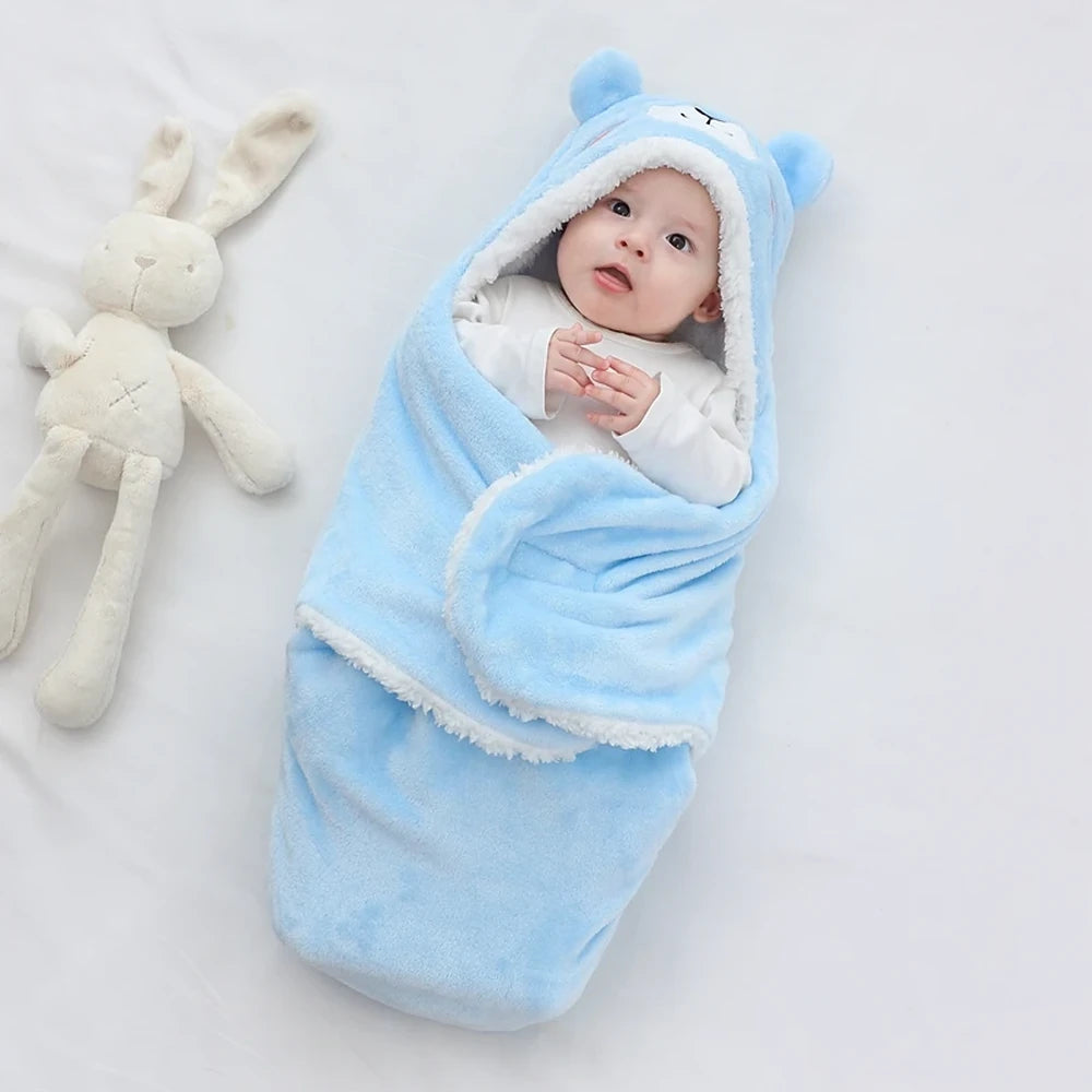 Bébé éveillé enveloppé dans la couverture à capuche ours bleu, rabats fermés