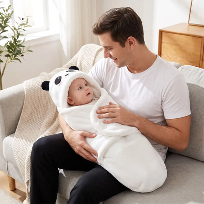 Bébé éveillé dans le nid d'ange bébé blanc à capuche panda, sur les genoux de son papa au salon