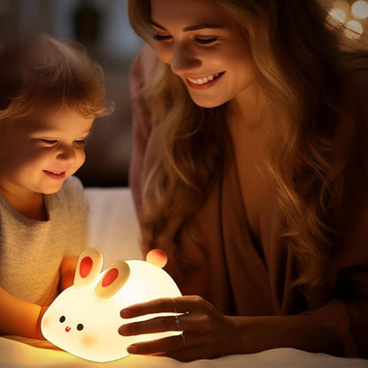 Parent et enfant souriant devant une veilleuse lapin chaleureuse.
