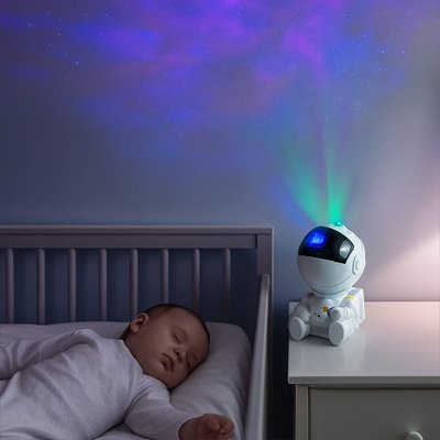 Projecteur galaxie robot apaisant bébé dans son lit.