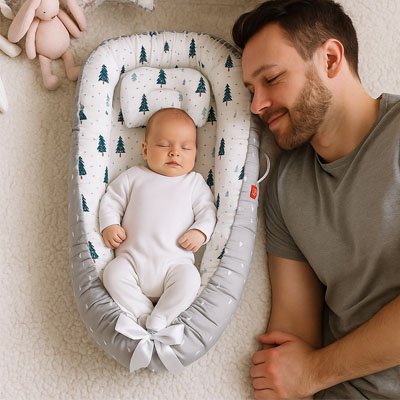 Réducteur de lit bébé sapins gris papa nouveau-né souriant
