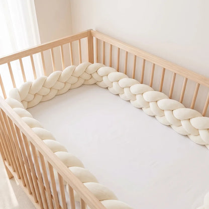 Natte à quatre brins crème le long d'un lit à barreaux vide