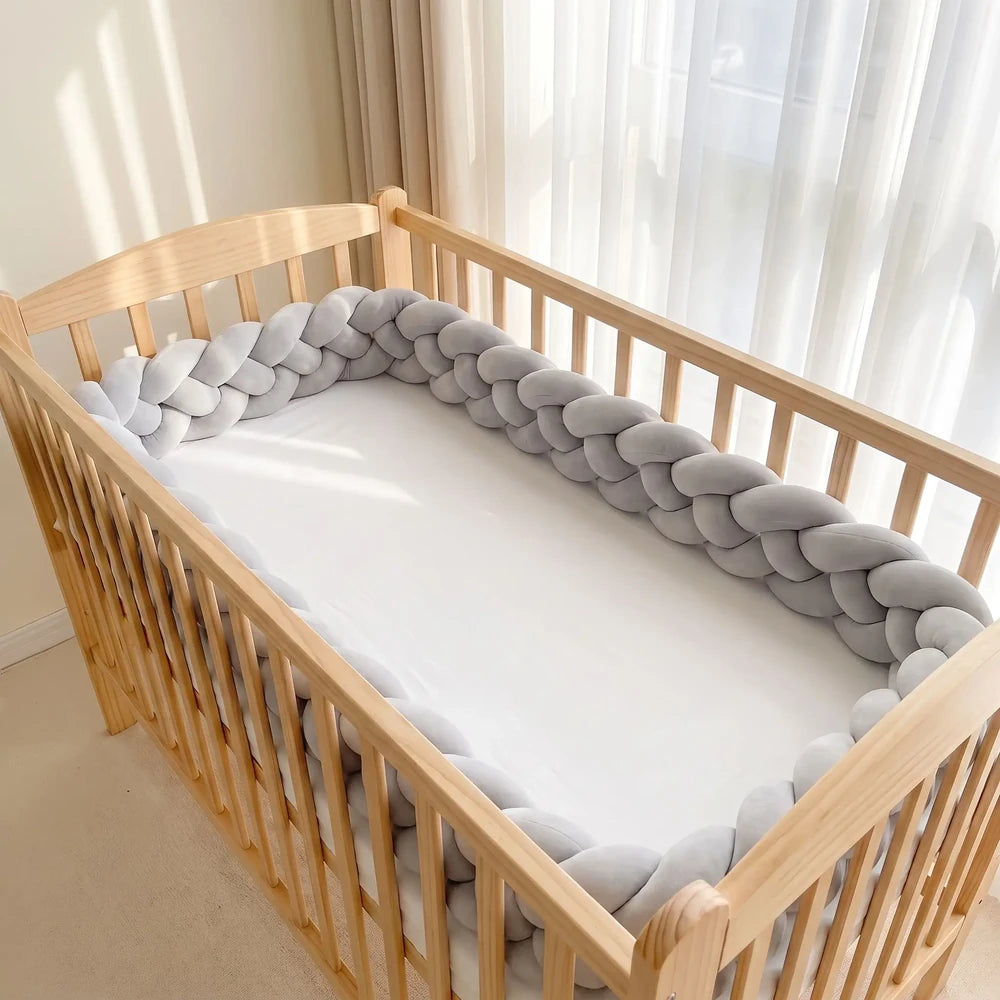 Natte à quatre brins gris clair dans un lit à barreaux vide