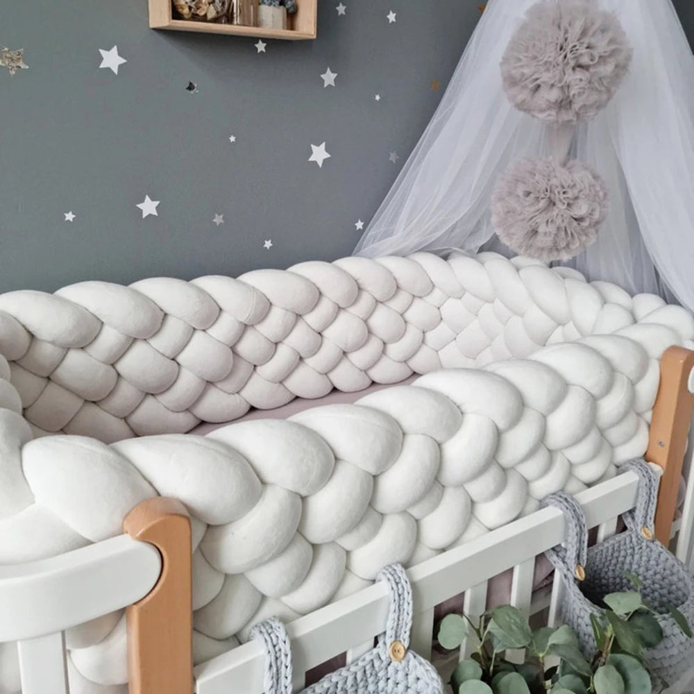 Tresse de lit bébé 6 brins blanche sur le bord d'un lit à barreaux