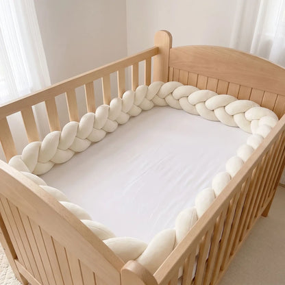Tresse de lit crème à 3 brins le long d'un lit à barreaux vide