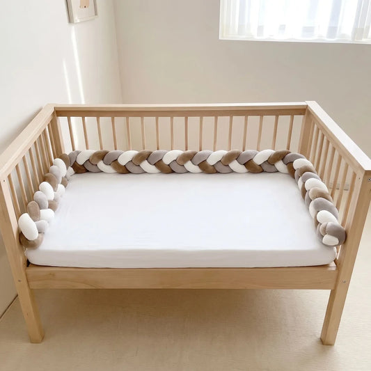 Tresse de lit marron, blanc et gris à 3 brins dans un lit à barreaux vide