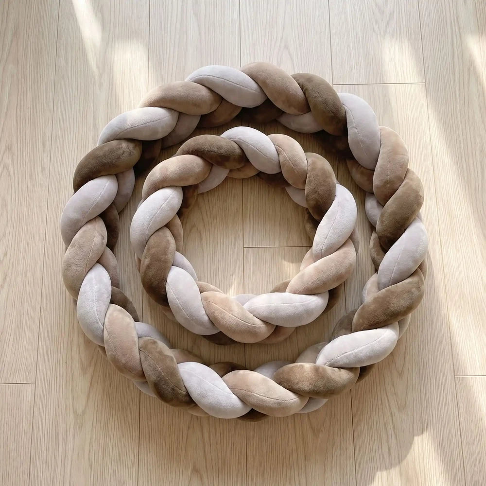 Tresse marron, taupe et gris clair à 3 brins enroulée sur un parquet clair