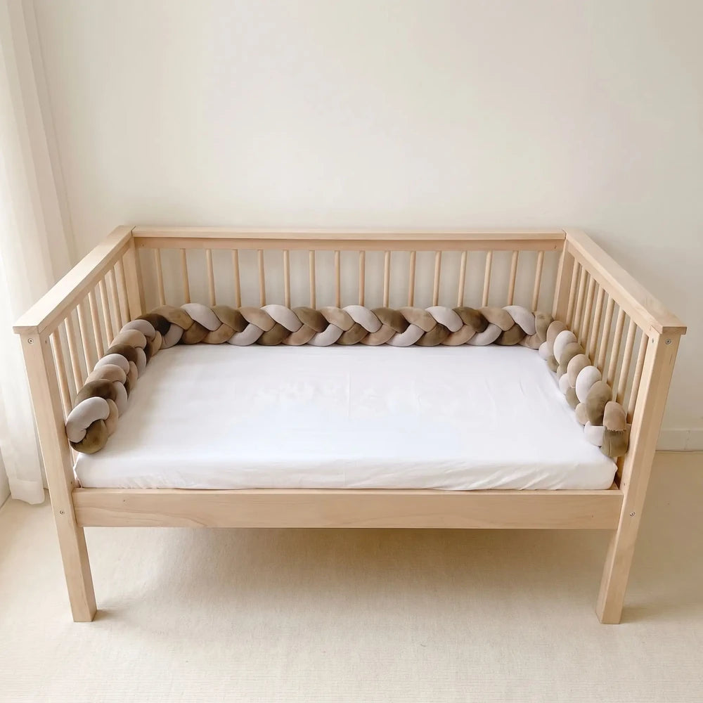 Tresse marron, taupe et gris clair dans un lit à barreaux vide