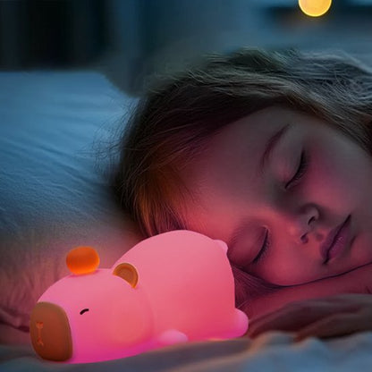 Veilleuse rechargeable rose rassurant un enfant endormi.